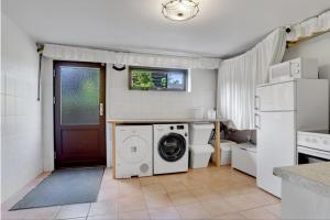 a kitchen with a washer and dryer next to a door at Kristensen b@b in Hjallerup