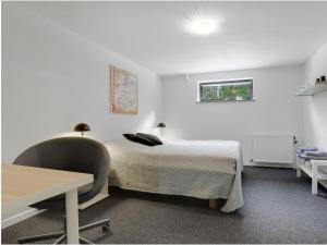 a bedroom with a bed and a desk and a table at Kristensen b@b in Hjallerup