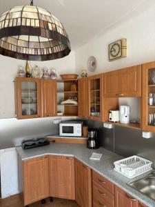 a kitchen with wooden cabinets and a large chandelier at Apartments & Restaurant Tkalcovsky dvur in Prague