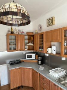 kuchnia z drewnianymi szafkami i dużym żyrandolem w obiekcie Apartments & Restaurant Tkalcovsky dvur w Pradze