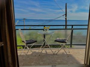 einen Tisch und Stühle auf einem Balkon mit Meerblick in der Unterkunft JUMA in Jesenice