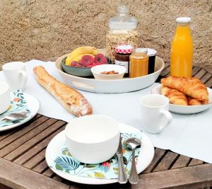 une table avec des assiettes de nourriture, des tasses et des croissants dans l'établissement La Bergeronnette, à Montreuil-Bellay