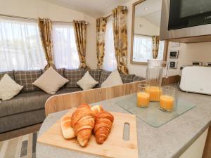 einen Tisch mit Croissants und Gläsern Orangensaft in der Unterkunft Horizon in Combe Martin