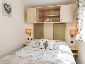 Dormitorio pequeño con cama y armarios en Horizon en Combe Martin
