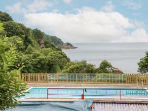 a swimming pool with a view of the ocean at Horizon in Combe Martin