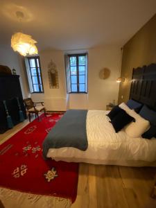een slaapkamer met een groot bed en een rood tapijt bij Dar Aminya - Chambres d'hôtes in Marmande