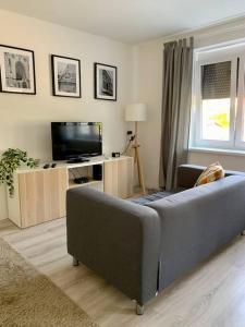 ein Wohnzimmer mit einem Sofa und einem Flachbild-TV in der Unterkunft Interno Casa in Sopron