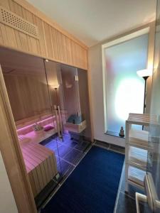 a room with a large window and a room with pink sheets at Jacuzzi - Sauna - BBq - Jardin - Garden Lodge - Myosotis in Olne