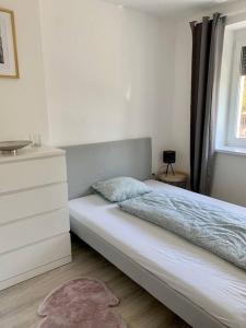 ein Schlafzimmer mit einem Bett, einer Kommode und einem Fenster in der Unterkunft Interno Casa in Sopron