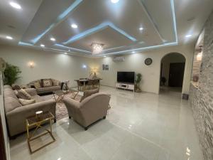 a large living room with couches and a tv at العلا بيتك in Al-ʿUla