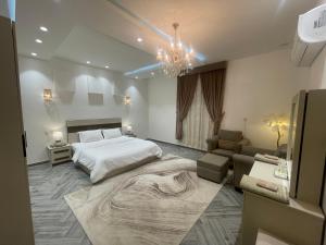 a bedroom with a large bed and a couch at العلا بيتك in Al-ʿUla