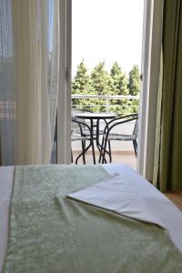 a bedroom with a bed and a balcony with a table at Apartments Fati & Flori in Ulcinj