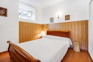 una camera con un letto bianco e pannelli in legno di Casa do Mar - Golf Jamor a Oeiras Altre 32 foto