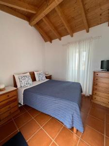 a bedroom with a bed and a wooden ceiling at Sudoeste Guest House in Odeceixe