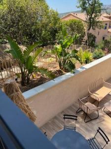 a patio with chairs and a table and a fence at La Belle de Cassis in Cassis