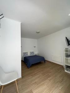 a bedroom with a bed and a wooden floor at Sudoeste Guest House in Odeceixe