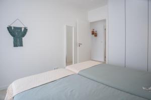 a white bedroom with a large bed in a room at Iris Apartment in Nazaré