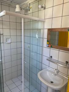 La salle de bains est pourvue d'une douche et d'un lavabo. dans l'établissement Pousada Fortaleza, à Parati