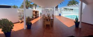 a balcony with a table and chairs and a pool at Casa Costa Bella in Costa Teguise