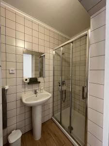 ein Bad mit einem Waschbecken und einer Dusche in der Unterkunft Sudoeste Guest House in Odeceixe