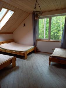 ヴィリニュスにあるLesnoy holiday homeのベッド2台と窓2つが備わる客室です。