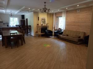 Lesnoy holiday home في فيلنيوس: غرفة معيشة مع أريكة وطاولة وكراسي