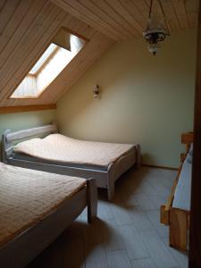 sypialnia na poddaszu z 2 łóżkami i świetlikiem w obiekcie Lesnoy holiday home w Wilnie