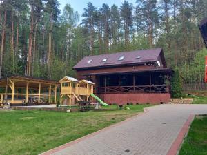 un gran edificio con un parque infantil y una casa en Lesnoy holiday home en Vilna
