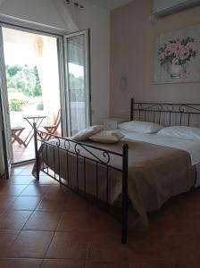 a bedroom with a large bed and a balcony at B&B Le Rose in Santa Maria di Castellabate
