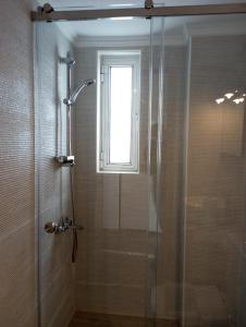 a shower with a glass door and a window at Sunshine Apartments in Kato Daratso +46 photos