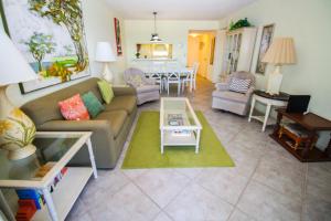 uma sala de estar com um sofá e uma mesa em Sea Coast Gardens III 303 em New Smyrna Beach