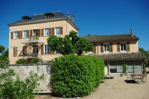 une grande maison avec un arbre en face dans l'établissement Le Clos des Tanneurs, à Taponas