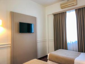 a hotel room with two beds and a flat screen tv at El Misti Hotel Buenos Aires Centro in Buenos Aires