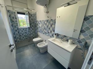 La salle de bains est pourvue d'un lavabo, de toilettes et d'un miroir. dans l'établissement Marè Diamante, à Diamante