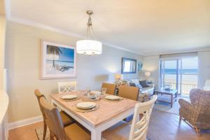 uma sala de jantar e sala de estar com mesa e cadeiras em Sea Coast Gardens II 105 em New Smyrna Beach