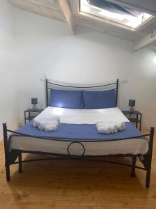 uma cama com lençóis e toalhas azuis e brancas em Casa del Vicolo em Alghero
