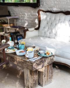 a table with plates of food on it with a bed at Hotel La Semilla a Member of Design Hotels in Playa del Carmen