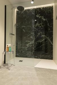 La salle de bains est pourvue d'une douche avec une porte en verre. dans l'établissement Hotel Encinar de Sotogrande, à Sotogrande