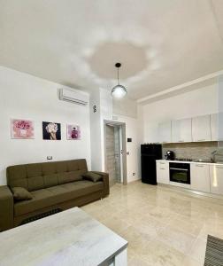 ein Wohnzimmer mit einem Sofa und einer Küche in der Unterkunft L'atelier - Locazione turistica in Scilla