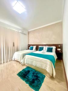 a bedroom with two beds and a rug at Lara's Home Suites in Capitólio +66 photos