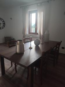 mesa de comedor de madera con sillas y ventana en B&B Sole e Luna en Scurcola Marsicana