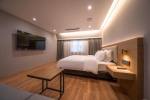 a bedroom with a white bed and a television at Comfort inn Yeouido in Seoul