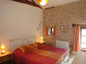 ein Schlafzimmer mit einem Bett und einer Ziegelwand in der Unterkunft GITE DU PUITS DE LA BARRE in Sompt