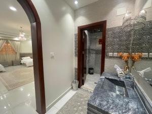 a bathroom with a shower and a sink and a mirror at العلا بيتك in Al-ʿUla