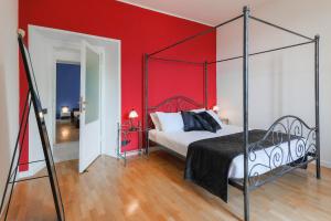 1 dormitorio con 1 cama con pared roja en La Dolce Vista by My Home In Como, en Moltrasio