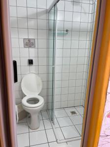 La salle de bains est pourvue de toilettes et d'une douche en verre. dans l'établissement Pousada Fortaleza, à Parati