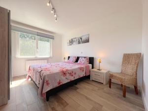 ein Schlafzimmer mit einem Bett, einem Stuhl und einem Fenster in der Unterkunft Devant les Thiers in Lierneux