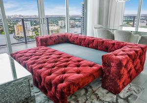 um sofá vermelho num quarto com uma grande janela em HYDE BEACH HOUSE #2408 THREE-BEDROOM, WATERFRONT, OCEAN AND INTERCOSTAL VIEW, ROOFTOP POOL, 5 MiN WALK TO BEACH em Hollywood