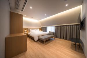 Habitación de hotel con cama y silla en Comfort inn Yeouido, en Seúl