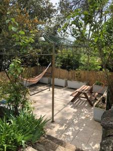 un patio con una hamaca y una valla en Villa spacieuse avec piscine proche de la mer en Biot
